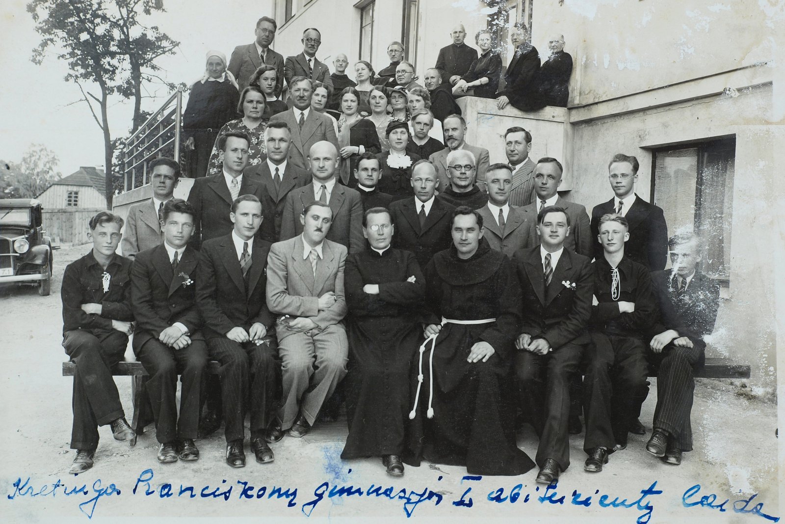 Kretingos Pranciškonų gimnazijos I abiturientų laida su jos vadovybe, pedagogais, tėvų komiteto nariais ir kt.: pirmoje eilėje penktas iš kairės – gimnazijos direktorius kun. Stasys Pupaleigis, šeštas – Šv. Antano kolegijos rektorius Augustinas Dirvelė; trečioje eilėje pirmas iš dešinės – Vincas Zajančkauskas ir kt. 1936 m.Autoriaus archyvas