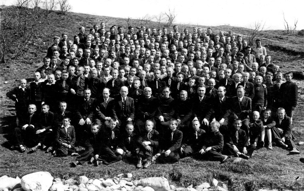 Pranciškonų gimnazijos vadovai, pedagogai, vienuoliai ir gimnazistai įsiamžinę gamtoje: trečias iš kairės sėdi direktoriaus pavaduotojas Juozas Gedgaudas, ketvirtas – direktorius Vincas Zajančkauskas ir kt. XX a. 4-as deš. Autoriaus archyvas
