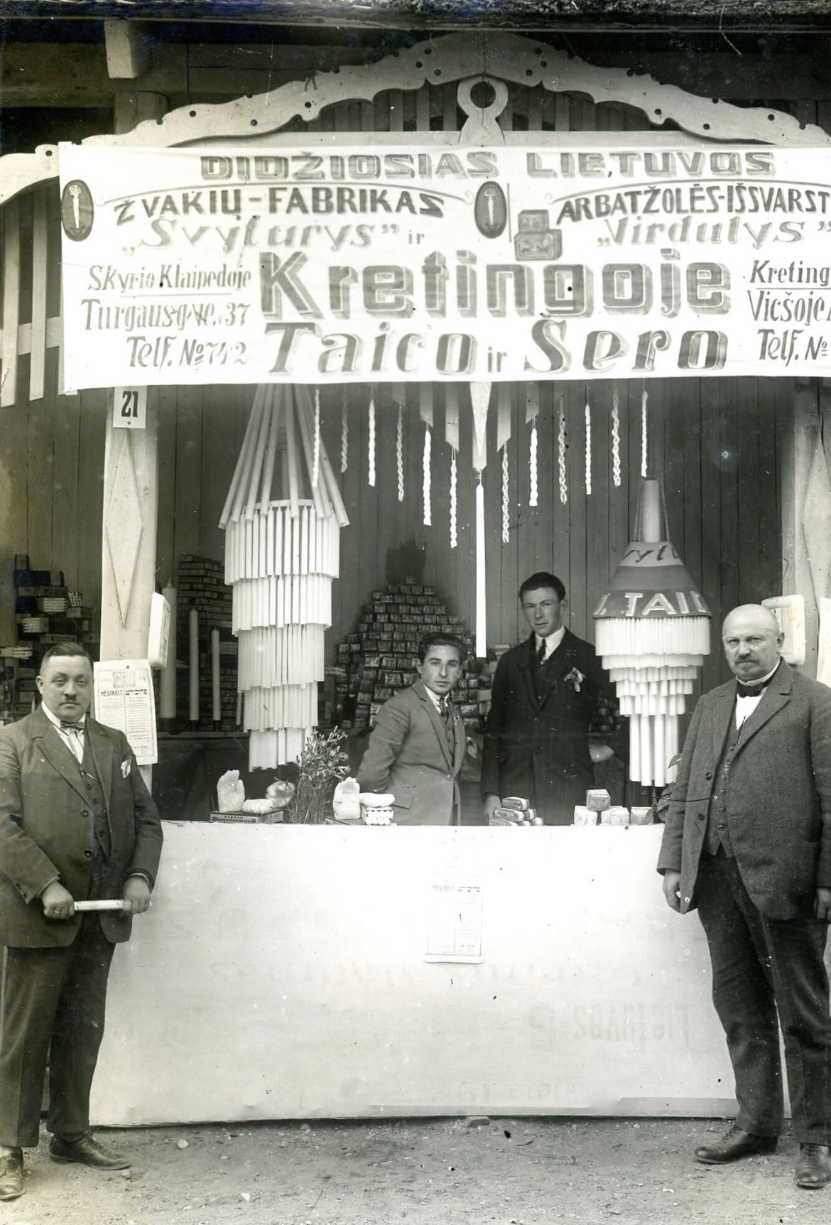Judelis Taicas (dešinėje) ir Enikas Šeras prie savo bendrovių reklaminio kiosko IV Lietuvos žemės ūkio ir pramonės parodoje Kaune 1925 m. Kauno apskrities viešosios bibliotekos archyvas