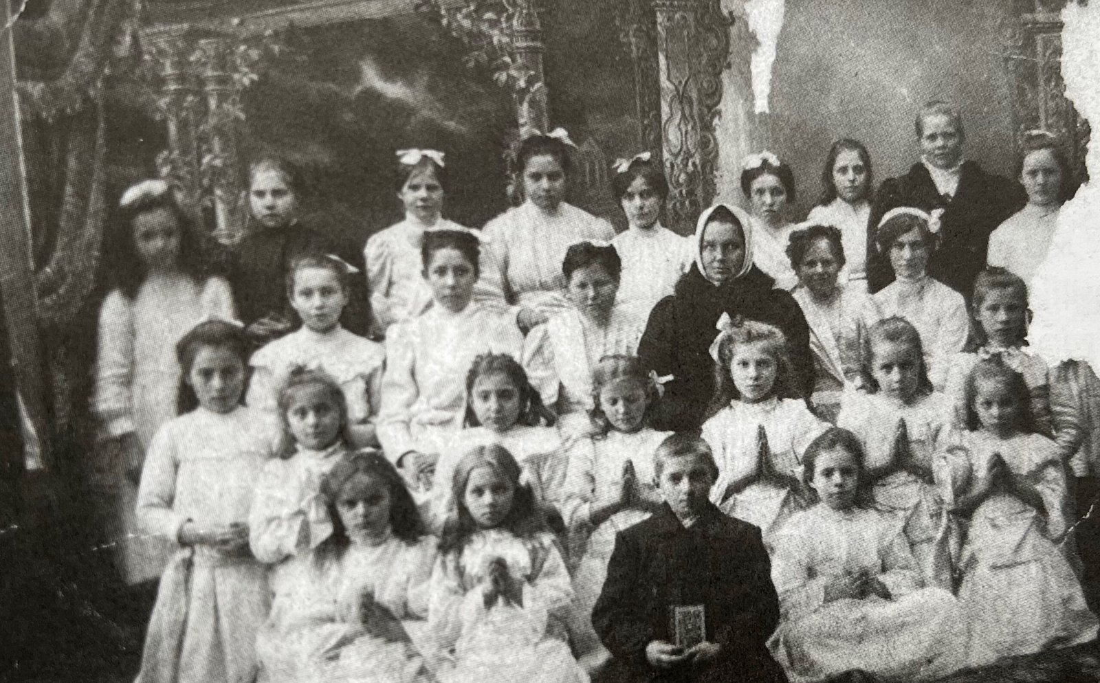 Seserys Emilija (antroje eilėje pirma iš dešinės) ir Elena (antra iš dešinės) Kretingos katalikų bažnyčioje per atlaidus ir šventes barstydavo gėles.1912 m., Meilutės Raštikytės-Alksnienės archyvas